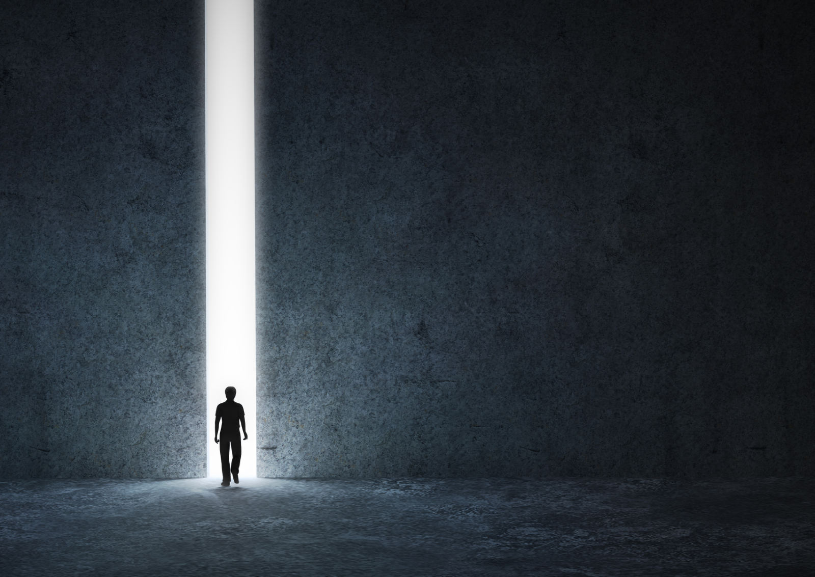 A small figure walking out of a bright, narrow doorway in a dark wall