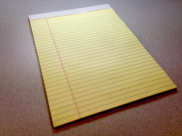 A blank yellow legal pad on a desk