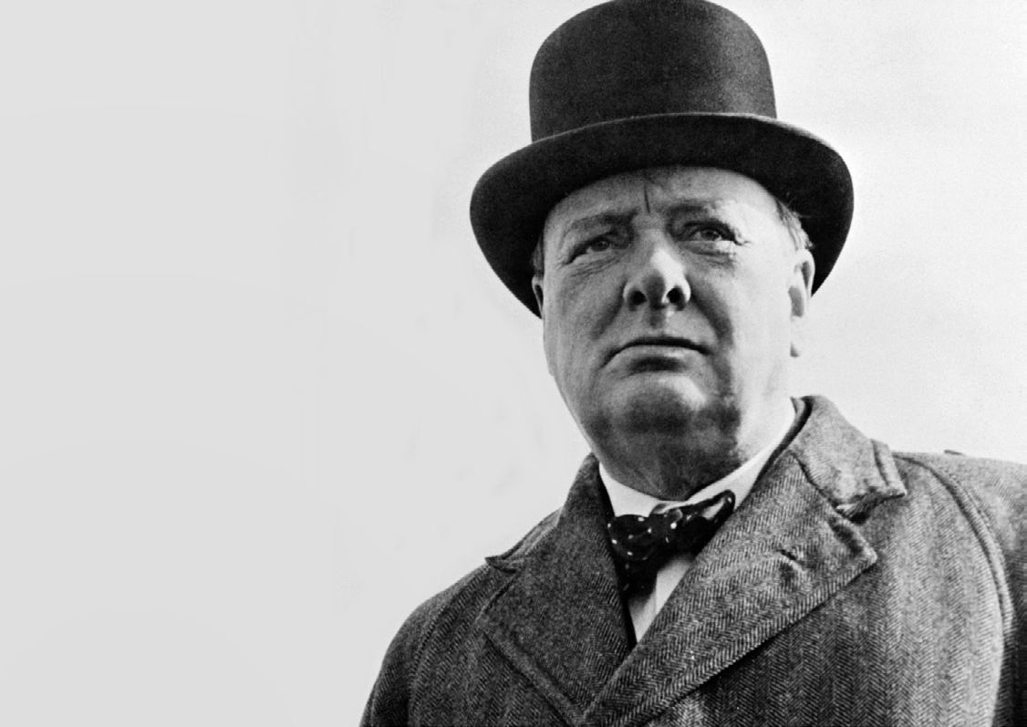 Winston Churchill in a bowler hat and bow tie, looking into the distance