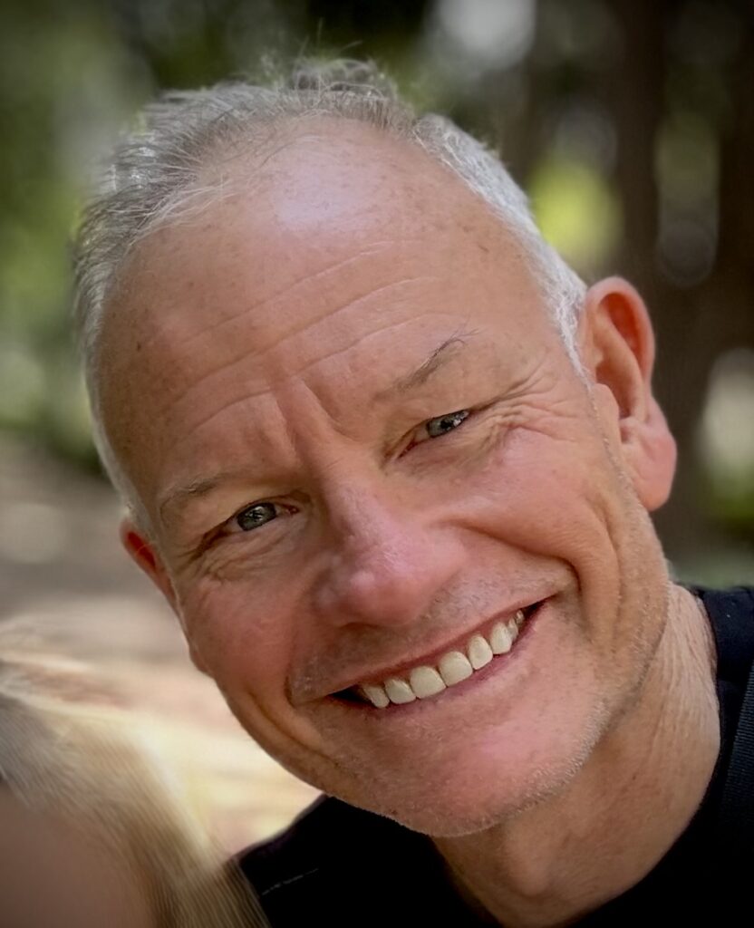 Ned Coten AM smiling, close-up portrait