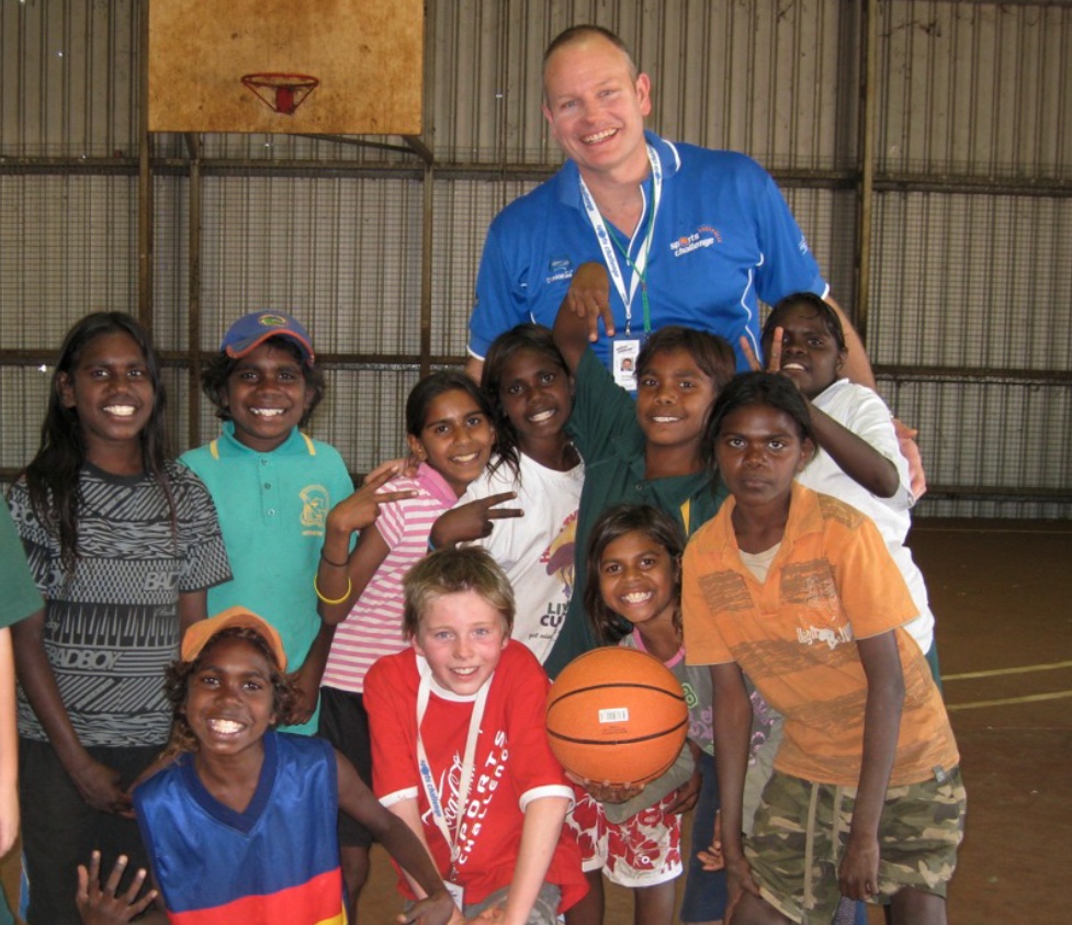 Ned Coten with children holding a basketball in Ngukurr