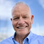 Ned Coten AM headshot in a blue shirt